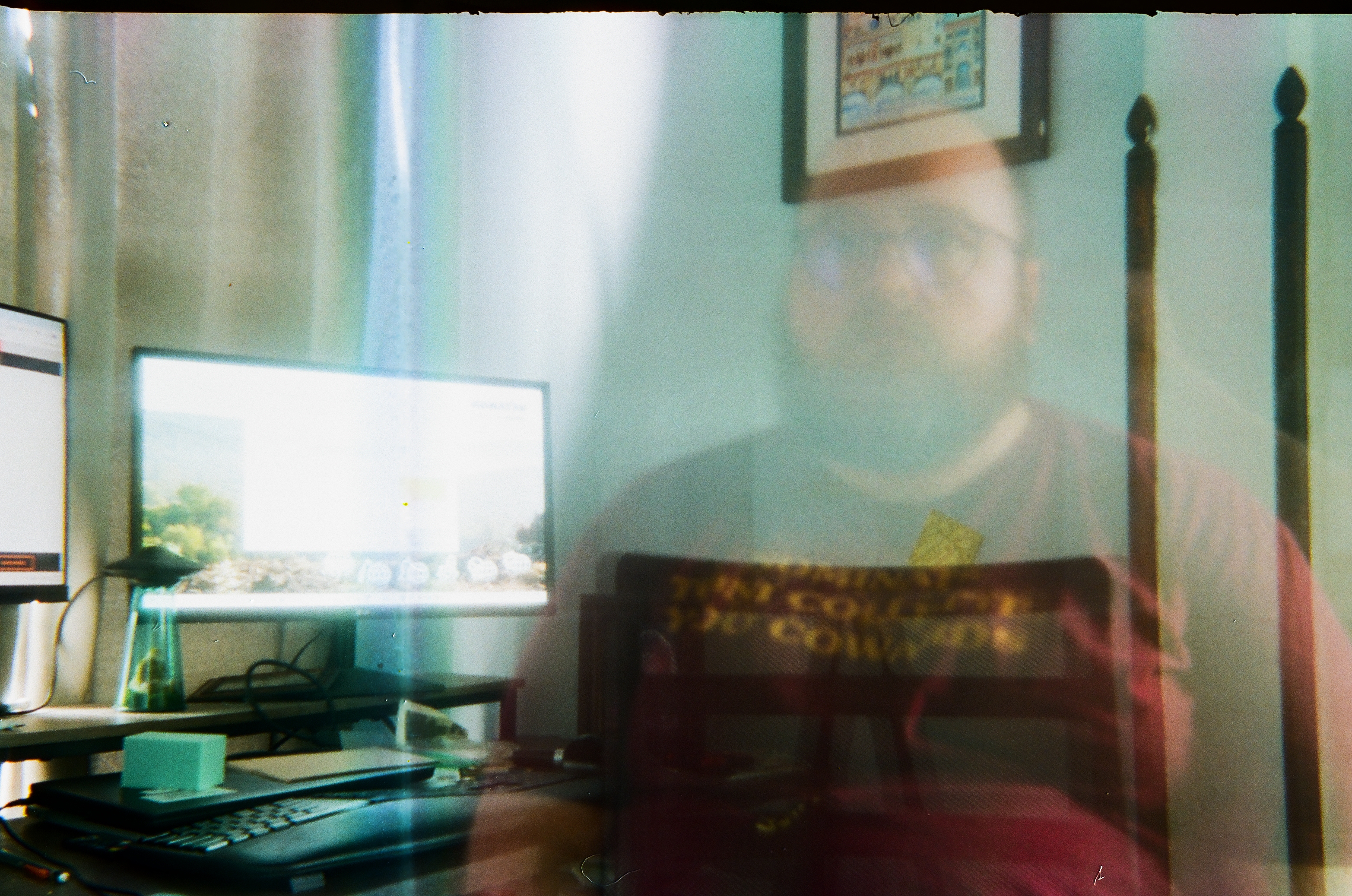 transparent man in a "nominate tony collette you cowards" t-shirt sitting at a desk